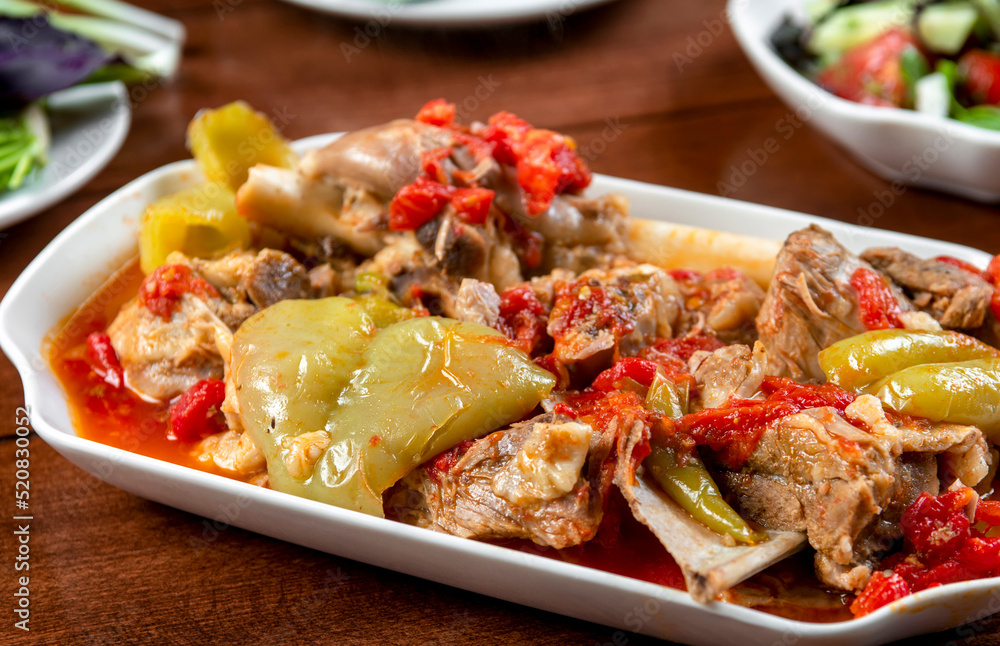 Khashlama is popular Armenian dish, which is prepared from beef with vegetables. Khashlama in the plate. stewed lamb on the bone with vegetables on wooden desk Khashlama is popular Armenian dish, which is prepared from beef with vegetables. Khashlama in the plate. stewed lamb on the bone with vegetables on wooden desk