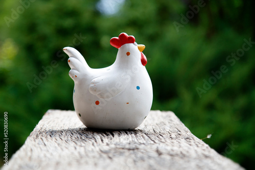 Clay figurine of a chicken on different backgrounds. Handmade clay white chicken. The concept of art, decorative toys, sculpture.