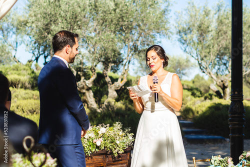 Foto Groom and bride read vows during their wedding