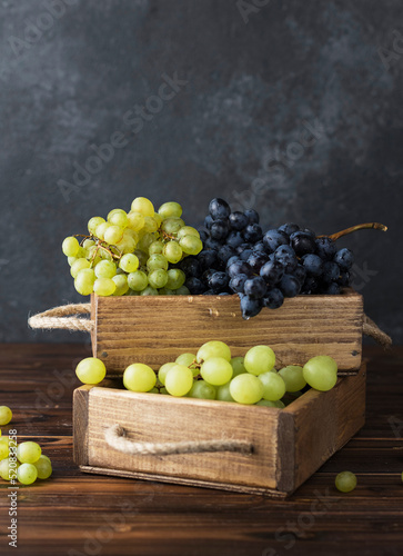 fresh juicy grapes in wooden box on table