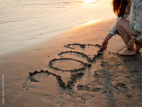 Happy New Year 2023 sign on sandy beach photo