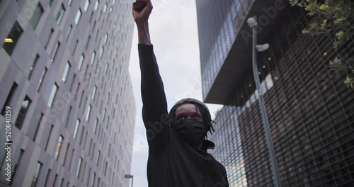 Young african american black man rasises his fists up in solidarity justice. 