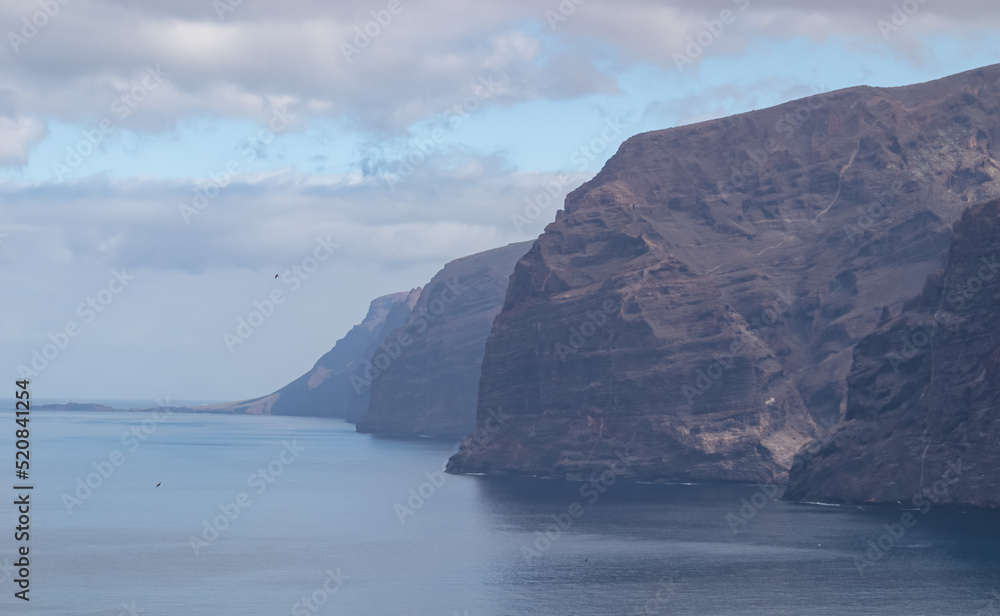 Panoramic view on the massive cliffs of Los Gigantes in Santiago del Teide, Western coast of Tenerife, Canary Islands, Spain, Europe. Rock formations along the coastline of the Atlantic Ocean. Freedom