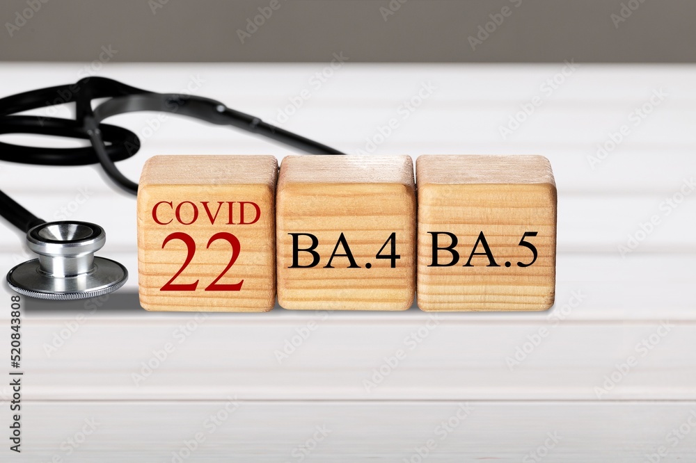Wooden blocks on the desk. Scientific symbols of the coronavirus evolved from the omicron. The concept of the spread of new mutations of the virus in 2022 Wooden blocks on the desk. Scientific symbols of the coronavirus evolved from the omicron. The concept of the spread of new mutations of the virus in 2022