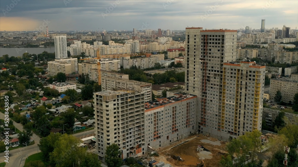 Landscape from a drone.Stock footage.Beautiful view of the city with tall houses and a large lake nearby and a gray sky overhead.