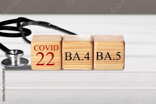 Wooden blocks on the desk. Scientific symbols of the coronavirus evolved from the omicron. The concept of the spread of new mutations of the virus in 2022 photo