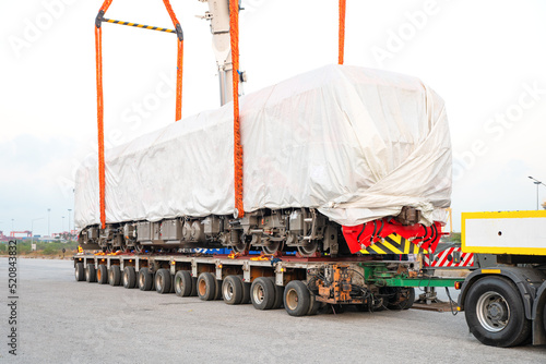 new electric diesel locomotive On the truck, waiting to be lifted onto the rails at the port  using  2 cranes lifting diesel-electric locomotives photo