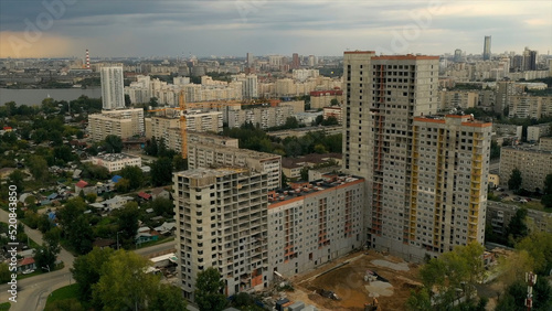 Landscape from a drone.Stock footage.Beautiful view of the city with tall houses and a large lake nearby and a gray sky overhead.
