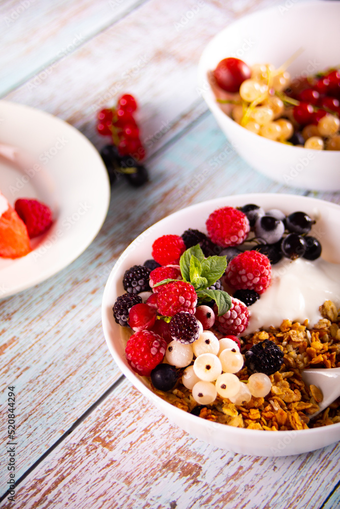 Granola, muesli cereals with yogurt or milk and fresh berries. Healthy breakfast concept.