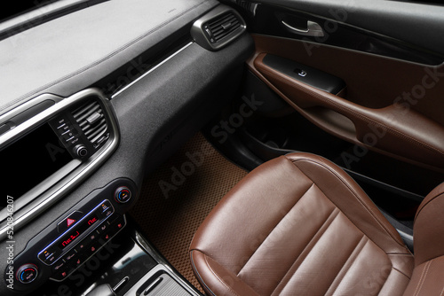 Car brown leather interior. Part of brown perforated leather car seat details with white stitching. Interior of prestige car. Comfortable perforated leather seats. Perforated leather. © Aleksei