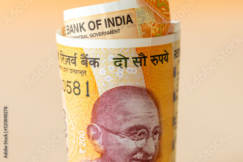 A rolled up roll of Indian money, New 200 rupee banknotes, financial business concept photo