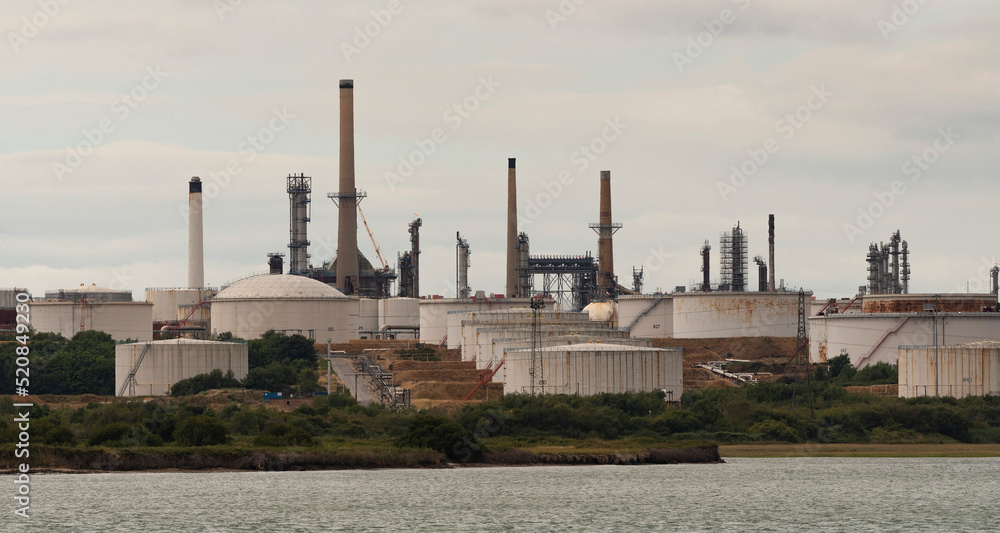 Southampton, southern England, UK. An exterior view of Fawley refinery, storage tanks and chimneys on Southampton Water, UK.