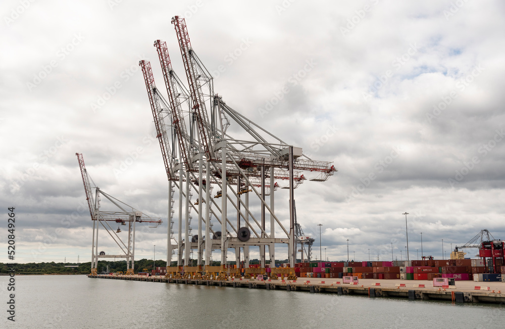 Southampton, England, UK. 2022. Large cranes waterside at a container ship terminal in southern England.
