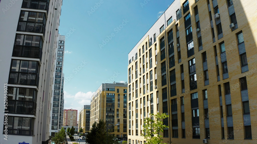 Fototapeta premium Contemporary residential buildings in the city. Stock footage. Exterior of a modern design of multistorey apartment buildings, aerial view.