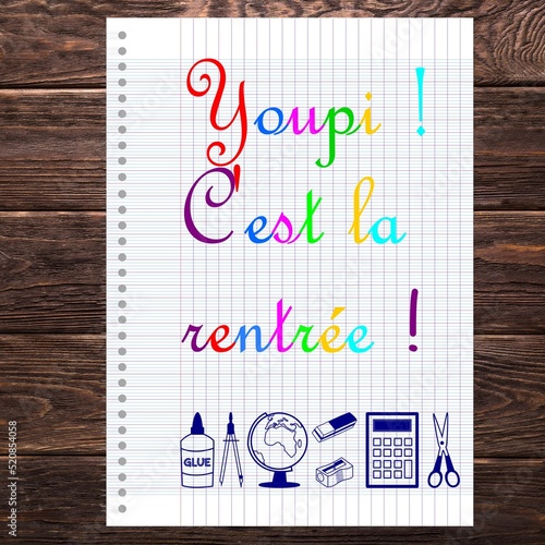 Youpi c'est la rentrée écrit en français sur une feuille de cahier d'écolier avec ciseau, calculatrice, compas, gomme