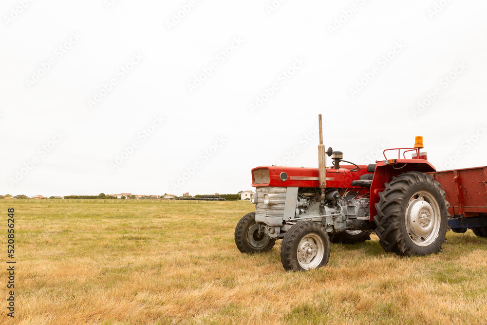 Tractor standing in a crop field. The day is cloudy. Concept of agriculture and rural life. Space for text. Tractor standing in a crop field. The day is cloudy. Concept of agriculture and rural life. Space for text.