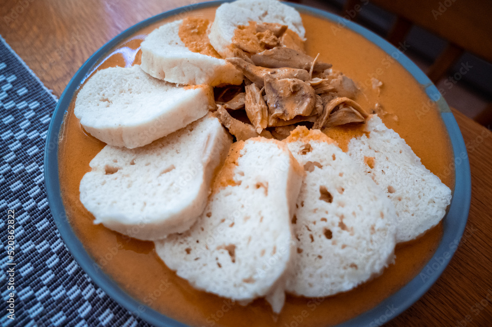 Traditional chicken hen on paprika or paprica creamy sauce with bread dumlings, typical czech food Traditional chicken hen on paprika or paprica creamy sauce with bread dumlings, typical czech food