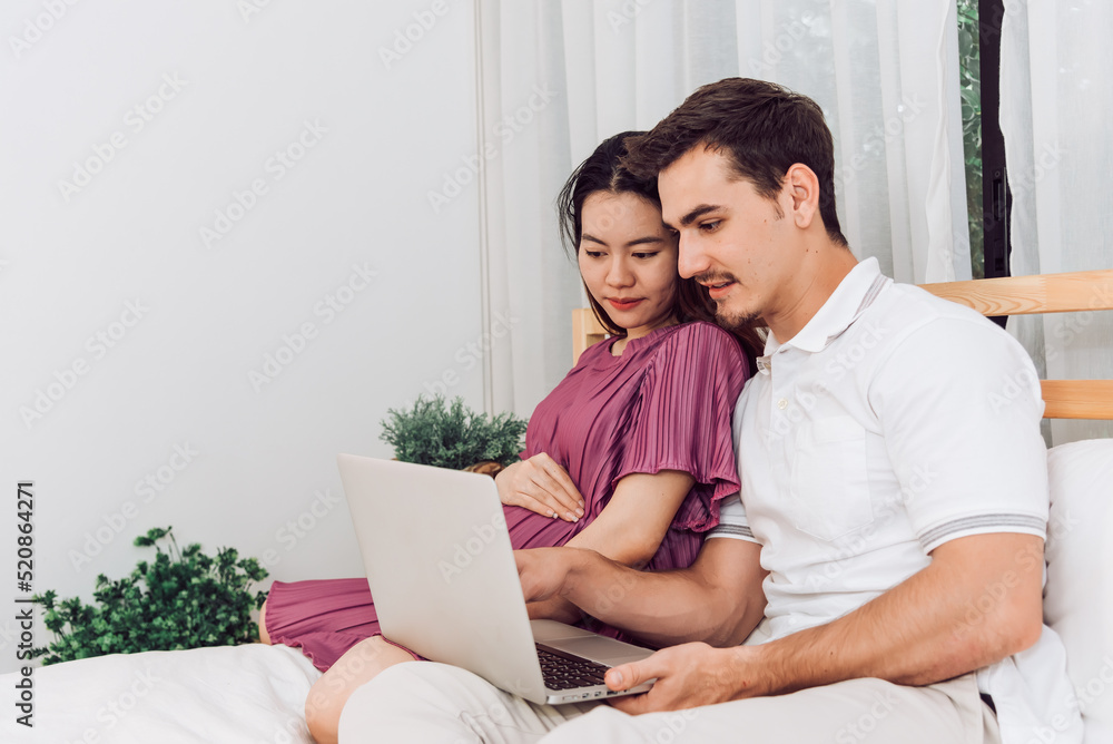 Happy couple pregnant woman and husband stay home in living room. Happy couple taking care together.
