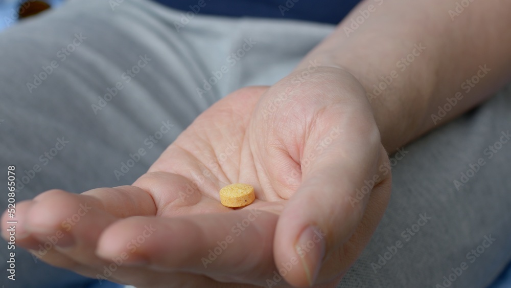 Close-up view of the palm into which two pills are poured and taken. Tablets in the hand of a patient suffering from a disease. Pill addiction. Drug addiction to medical drugs.