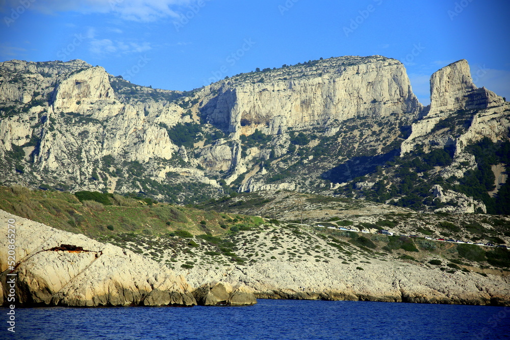 View of the steep rock face cliff of the badlands on the Mediterranean sea, under a clear blue sky, Parc National des Calanques, Marseille, France