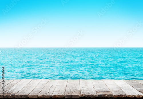 Empty wooden table or pier with sunny sea