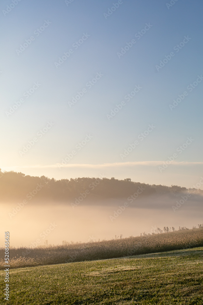 Countryside valley in the Holmes County farmland covered in a cloud of fog in the morning Countryside valley in the Holmes County farmland covered in a cloud of fog in the morning