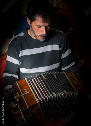 latin man musician playing tango with his bandoneon photo