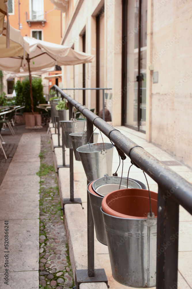 A row of hanging buckets in an open-air cafe as a decoration A row of hanging buckets in an open-air cafe as a decoration