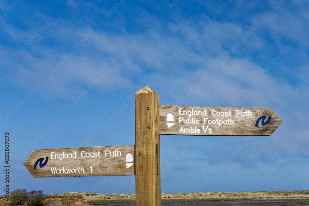 Fototapeta premium England coast path at the esturay of the river Coquet in Northumberland, Uk with signpost