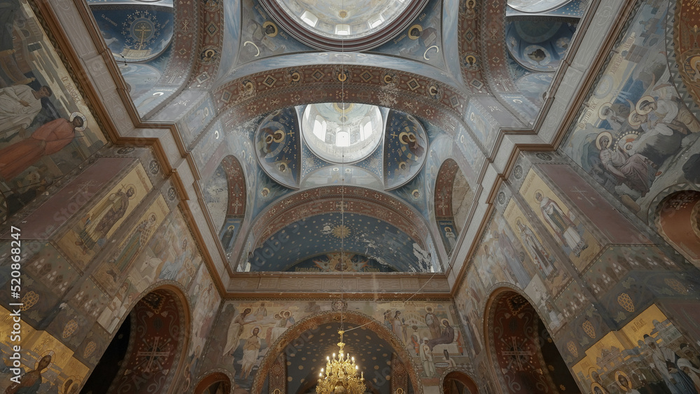 A painted church.Clip. A large temple with a huge ceiling that is painted with icons in a circle and small windows at the very top.