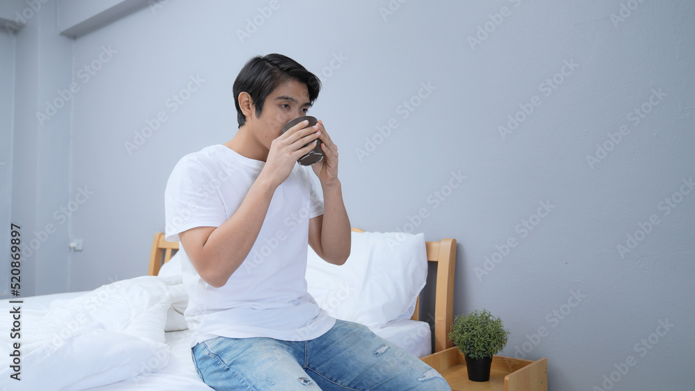 Holiday concept of 4k Resolution. Asian man drinking coffee happily in bedroom. fresh scent.