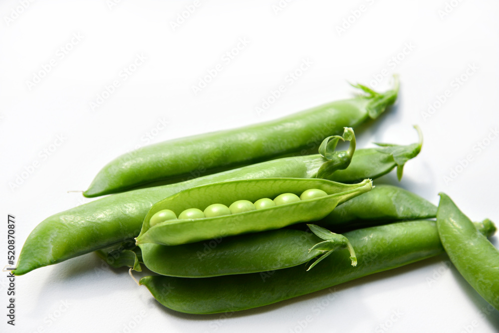 Pods of fresh green peas on a white background. Pods of fresh green peas on a white background.