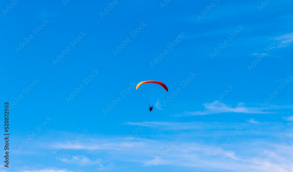Paramotor Flying through sunlight with Blue Sky. Paramotor Flying through sunlight with Blue Sky.