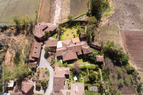Aerial view of a rural house in the countryside of Cusco Peru. House in Yucay town with roof tiles.
