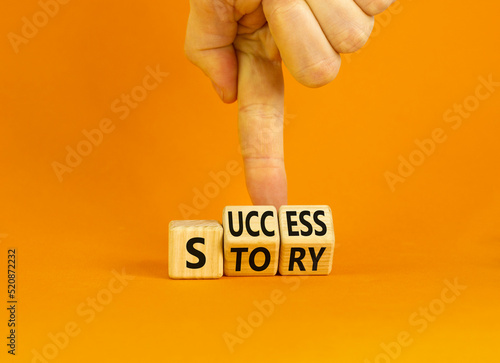 Success story symbol. Concept words Success story on wooden cubes. Businessman hand. Beautiful orange table orange background. Business and Success story concept. Copy space.