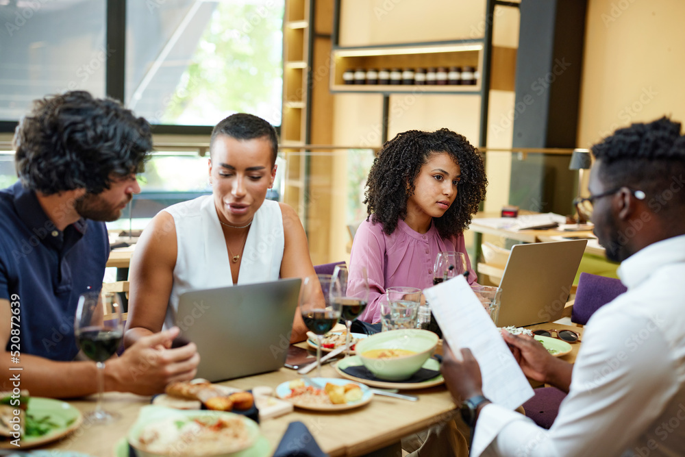 Corporate workers having casual business meeting in a restaurant during lunch. Corporate workers having casual business meeting in a restaurant during lunch.