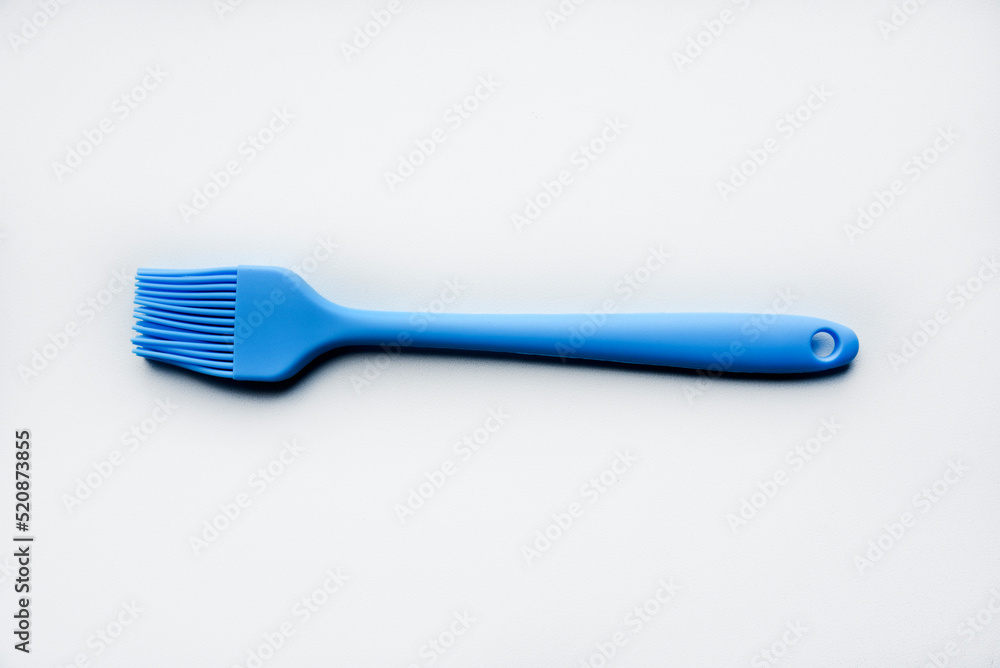 Blue plastic brush for smearing sunflower oil on a frying pan. A device for smearing oil. Blue plastic brush for smearing sunflower oil on a frying pan. A device for smearing oil.