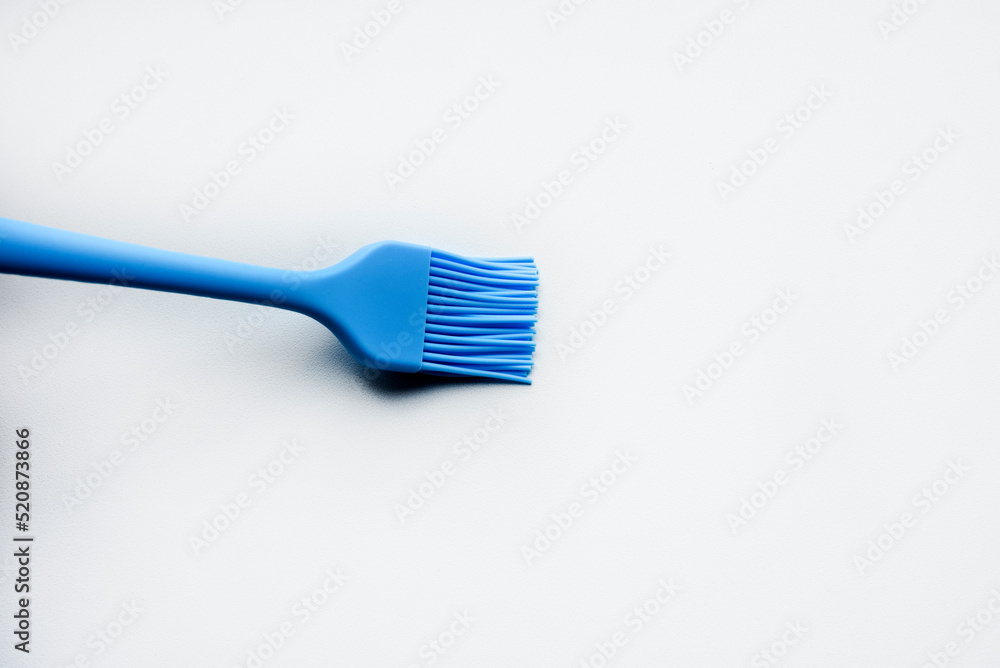 Blue plastic brush for smearing sunflower oil on a frying pan. A device for smearing oil. Blue plastic brush for smearing sunflower oil on a frying pan. A device for smearing oil.