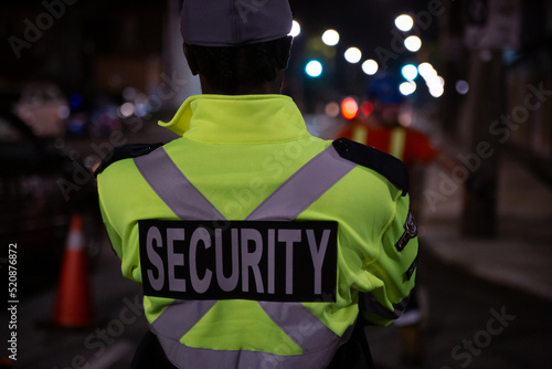 Security guard in car patroling at construction site at night city