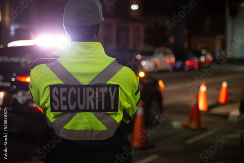 Security guard in car patroling at construction site at night  city