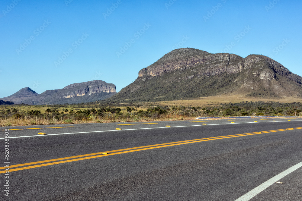 A highway crossing the Brazilian midwest surrounded by mountains of the cerrado biome. Landscape of Chapada. Nature photographer. Life in nature. Roadtrip. Blue sky. A highway crossing the Brazilian midwest surrounded by mountains of the cerrado biome. Landscape of Chapada. Nature photographer. Life in nature. Roadtrip. Blue sky.