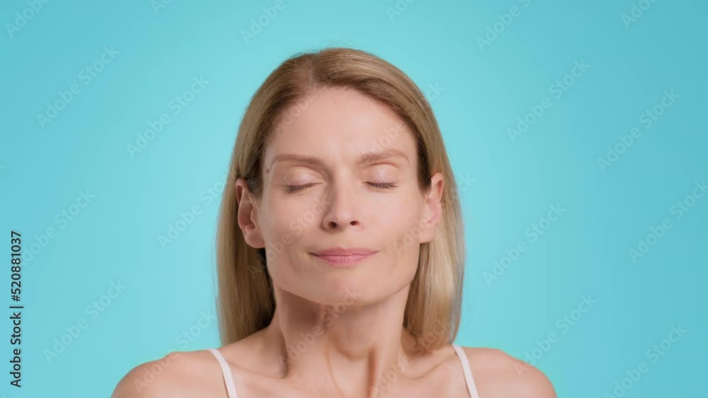 Runny nose treatment. Sick middle aged woman using nasal drops, getting treatment and smiling after relief effect Runny nose treatment. Sick middle aged woman using nasal drops, getting treatment and smiling after relief effect