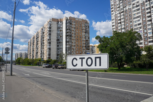 Stop sign on a white plate near a road on the street. Word Stop in Russian language © Natalia