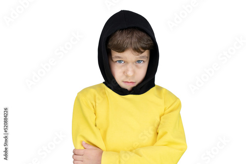 Young boy 6-8 years old in a warm sports jacket with a hood with a serious face on a white background, place for advertising, isolated