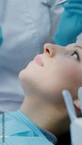 The dentist takes a medical instrument and examination oral cavity of a women