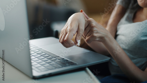 Close shot of the hands of a woman with spinal muscular atrophy surfing the Internet or social media typing on a laptop keyboard