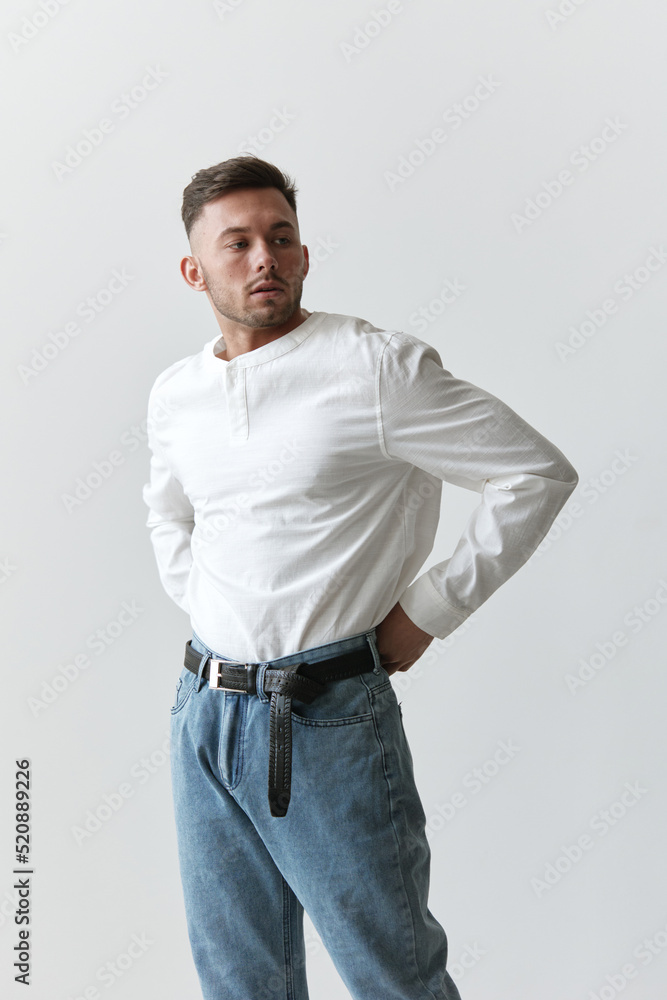 Handsome pensive attractive serious model man guy wear linen shirt looks aside posing isolated on white studio background. Fashion Style New Collection Sale ad concept. Copy space, banner. Model shoot Handsome pensive attractive serious model man guy wear linen shirt looks aside posing isolated on white studio background. Fashion Style New Collection Sale ad concept. Copy space, banner. Model shoot