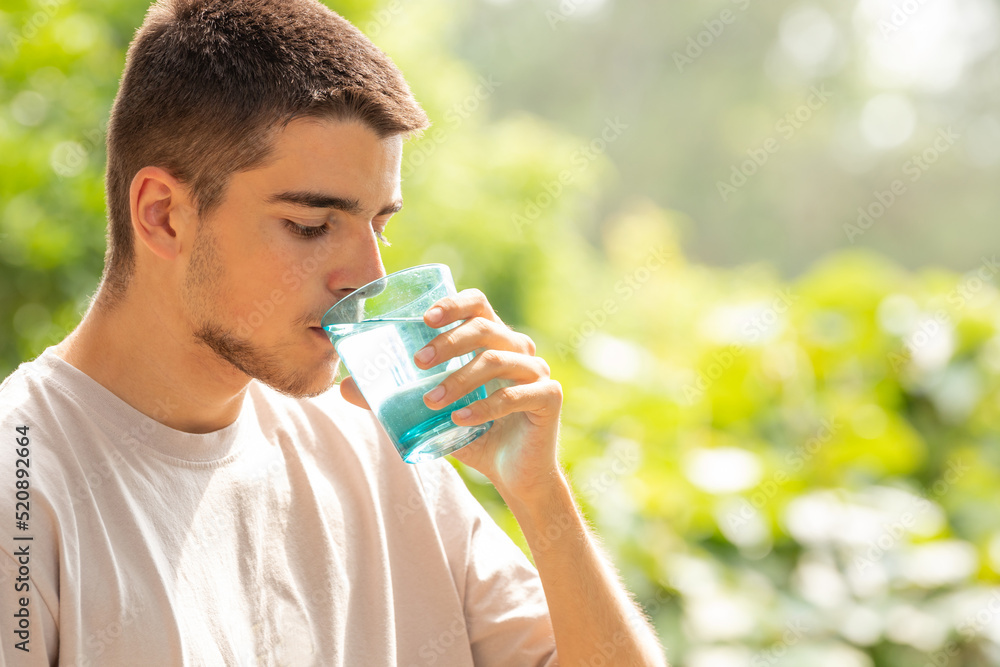 young man drinking water outdoors young man drinking water outdoors
