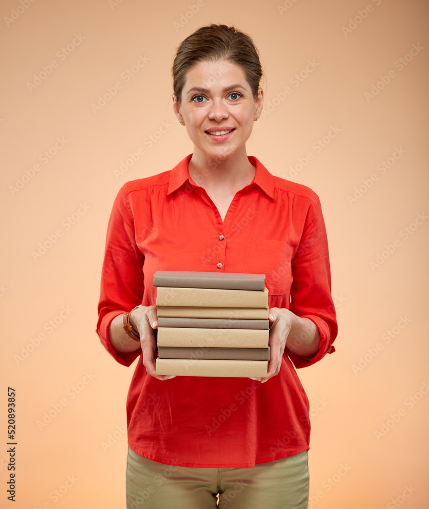 Obraz premium Student woman in red shirt holding books stack, isolated studio portrait.