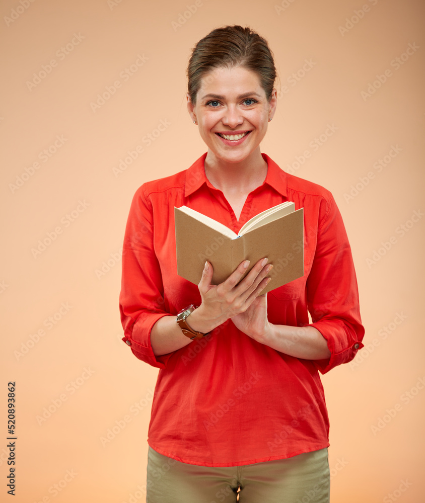 Smiling female student in red shirt holding open book, isolated studio portrait on beige, brown background. Smiling female student in red shirt holding open book, isolated studio portrait on beige, brown background.